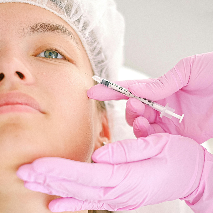 Woman receiving a Botox injection in her temple