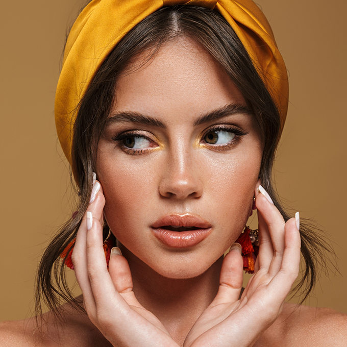 Young woman framing her face with her hands