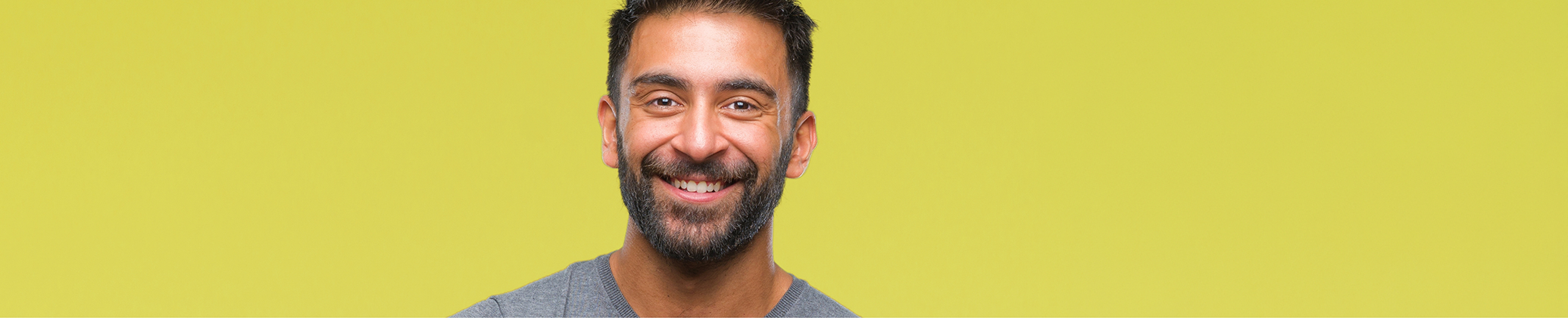 Man with black hair smiling after seeing his cosmetic dentist in Port Charlotte