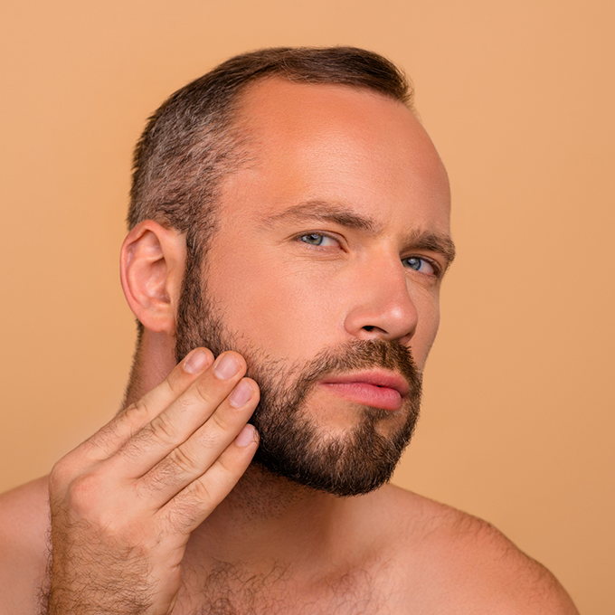 Man looking sterm while touching his face