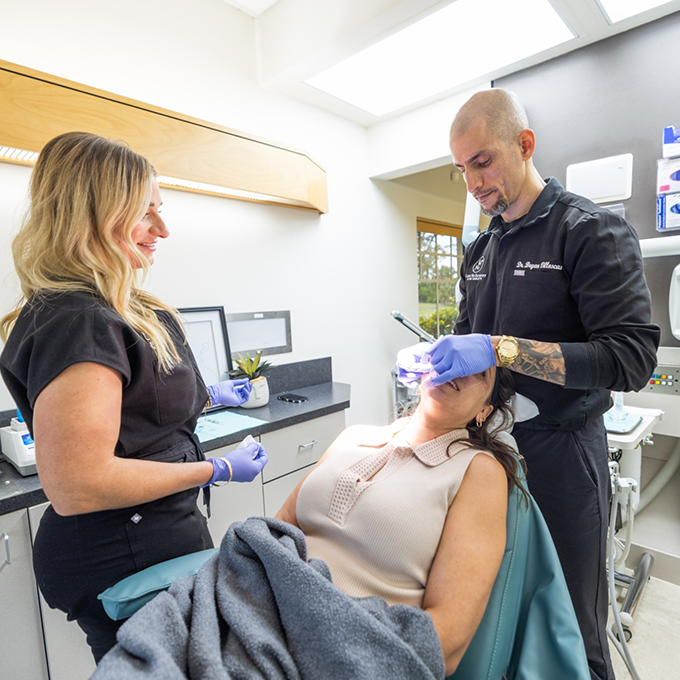Doctor V and an assistant performing an esthetic treatment on a patient