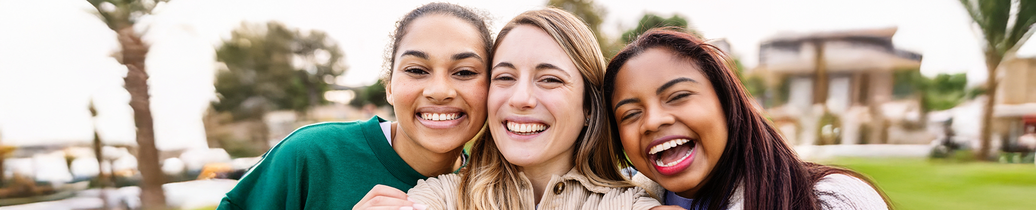 Three young woman smiling outdoors