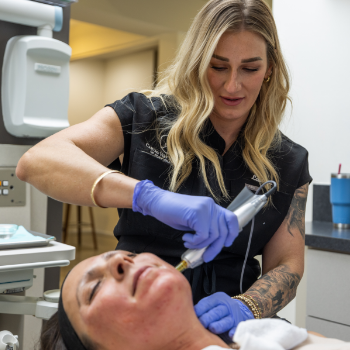 Esthetic professional using a laser device on a patients jawline