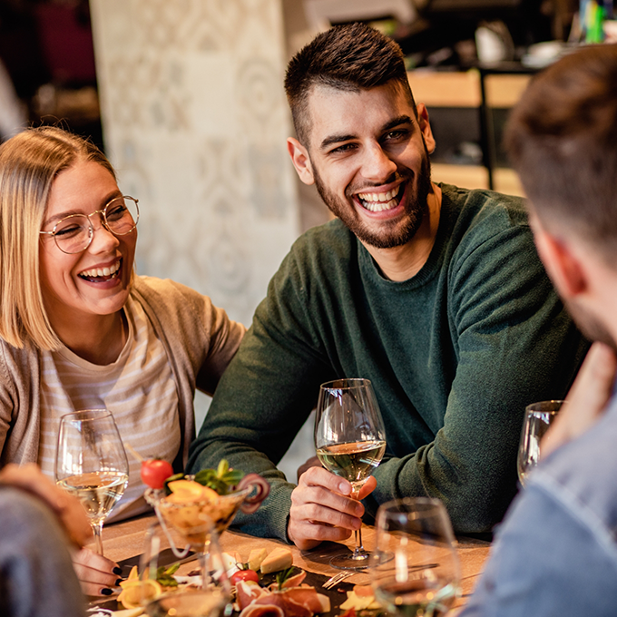 Group of adults laughing at a restaurant table