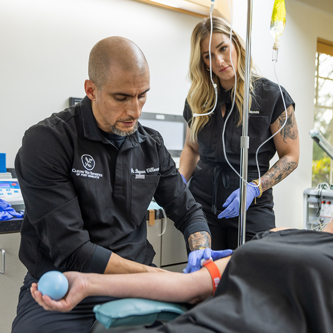 Doctor V and an assistant adjusting a patients I V