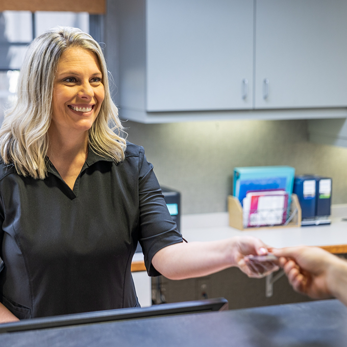 Patient handing their payment card to a receptionist