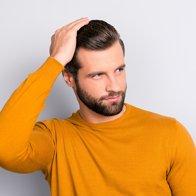 Man in a yellow sweater looking off to the side